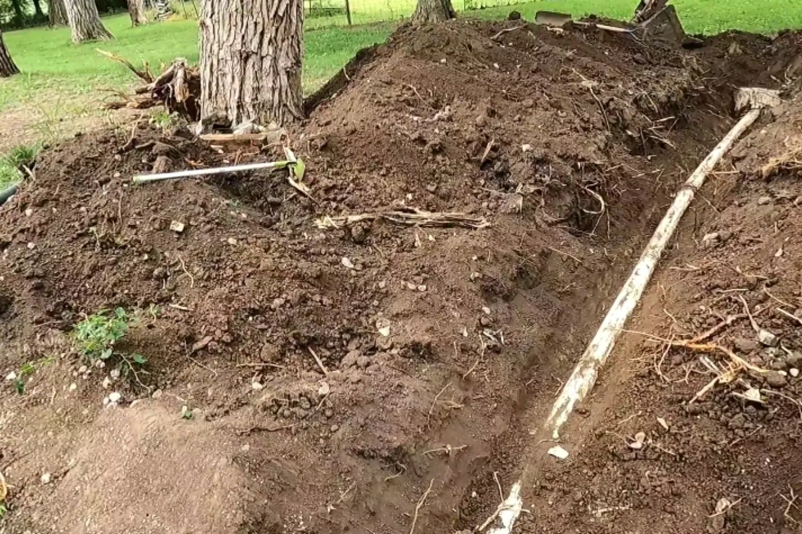 Trench dug across a yard for a sewer lateral replacement