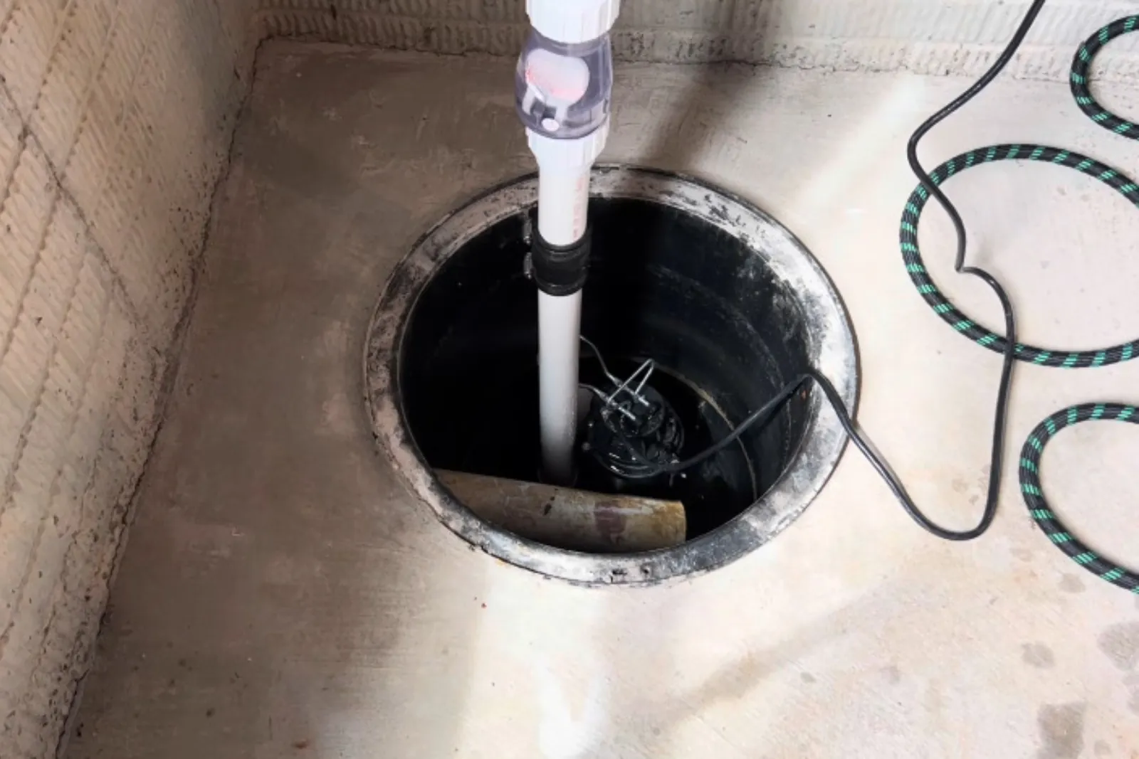 Submersible sump pump and discharge pipe installed in a basement sump pit